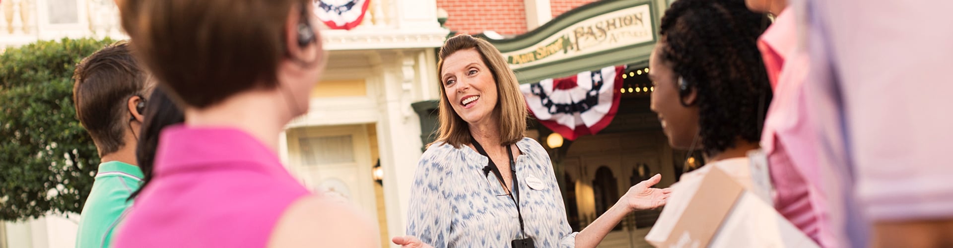A smiling Disney Institute facilitator talks with participants during a field experience